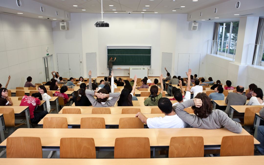 Widok sali wykładowej z uczniami i nauczycielem