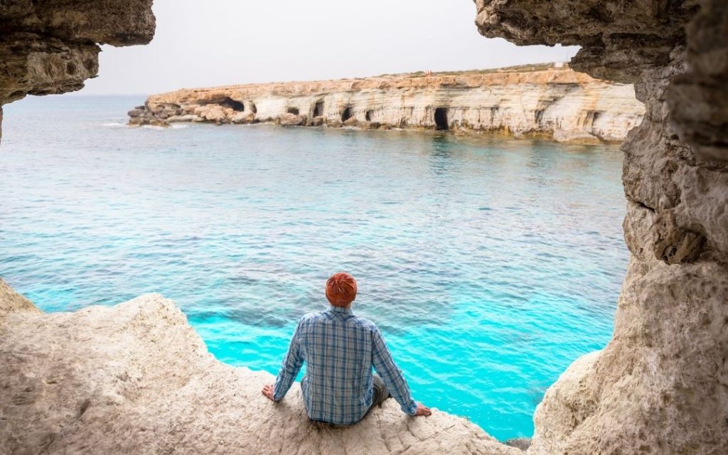 Wybrzeże Cypru z widokiem na skaliste jaskinie morskie i turkusową wodę Morza Śródziemnego.