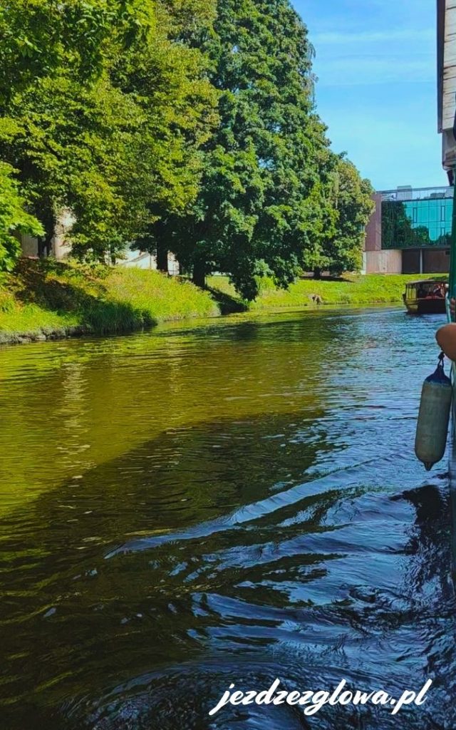 Widok na kanał otoczony parkiem w pełnym słońcu