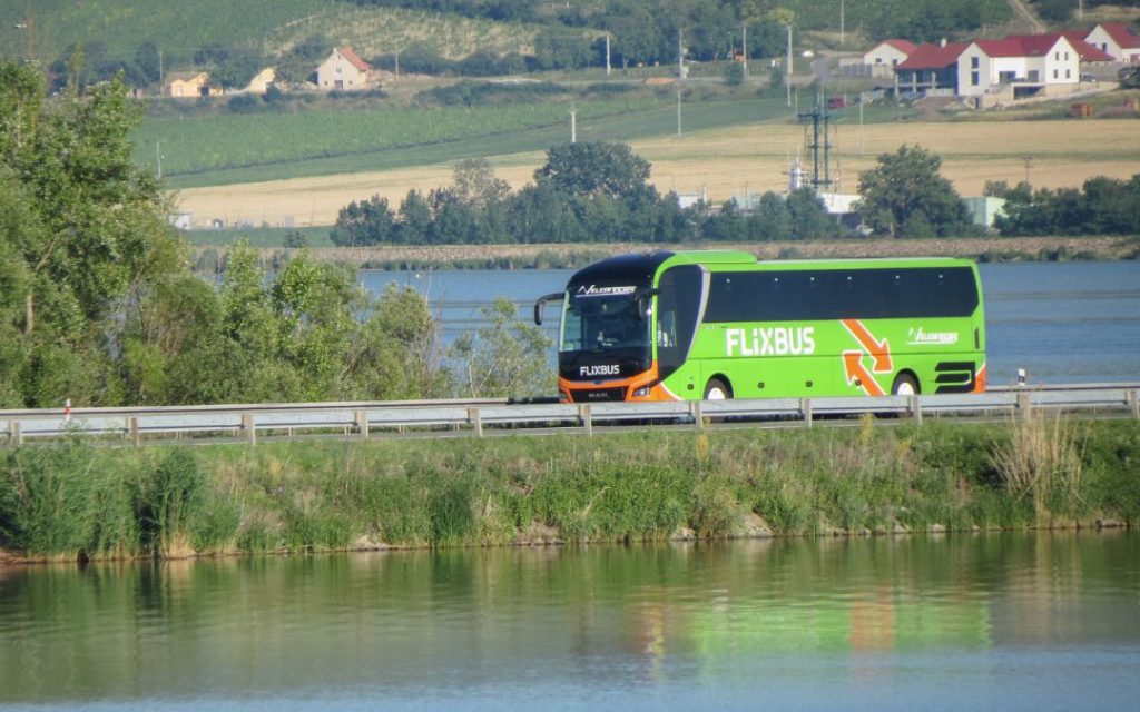 Flixbus jadący drogą obok jeziora