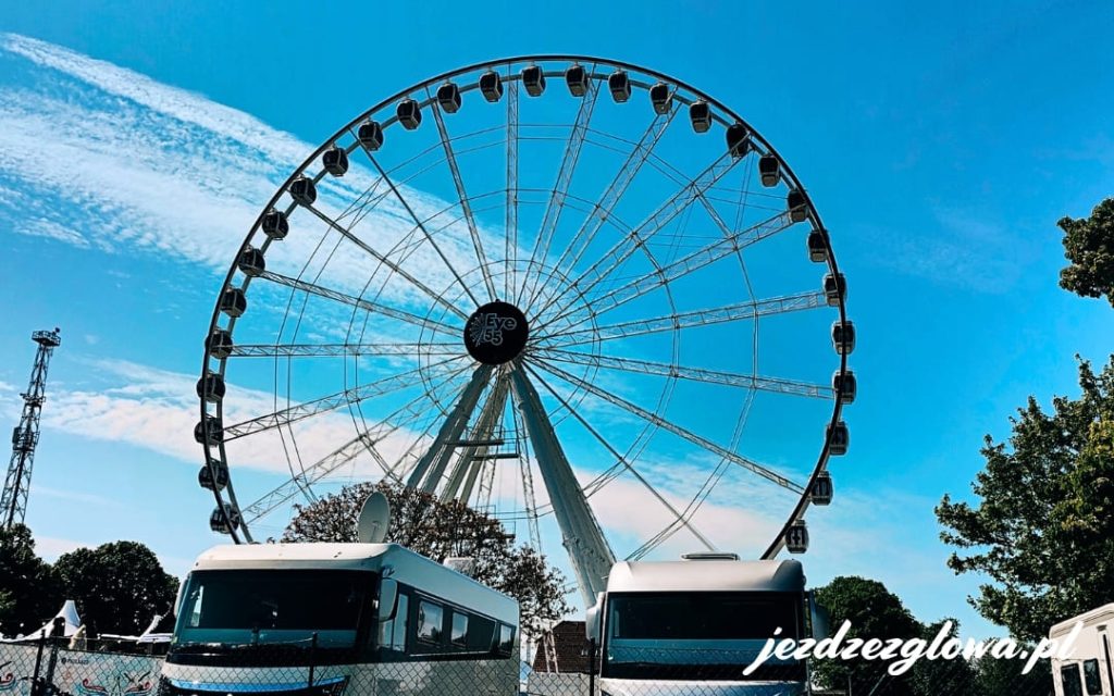 Kampery zaparkowane na molo w Warnemünde na tle diabelskiego młyna Eye55