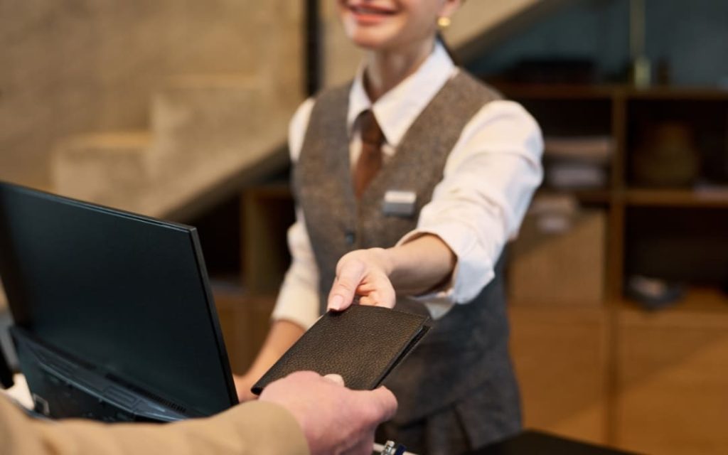 Obsługa hotelowa podająca książeczkę