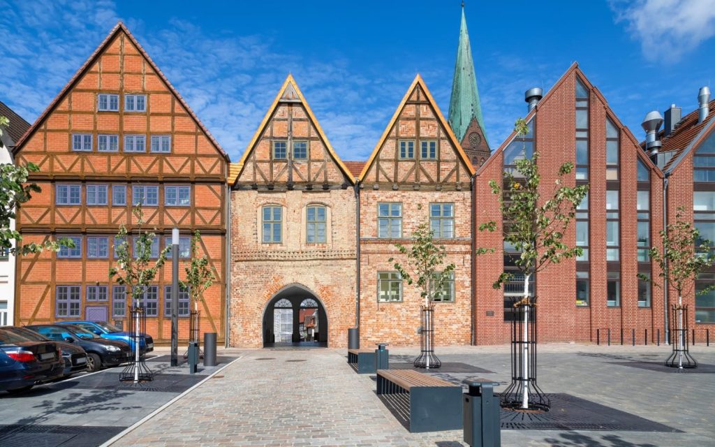 Słoneczny dzień na Schlachtermarkt w Schwerinie z zabudową z muru pruskiego i ceglaną architekturą miasta