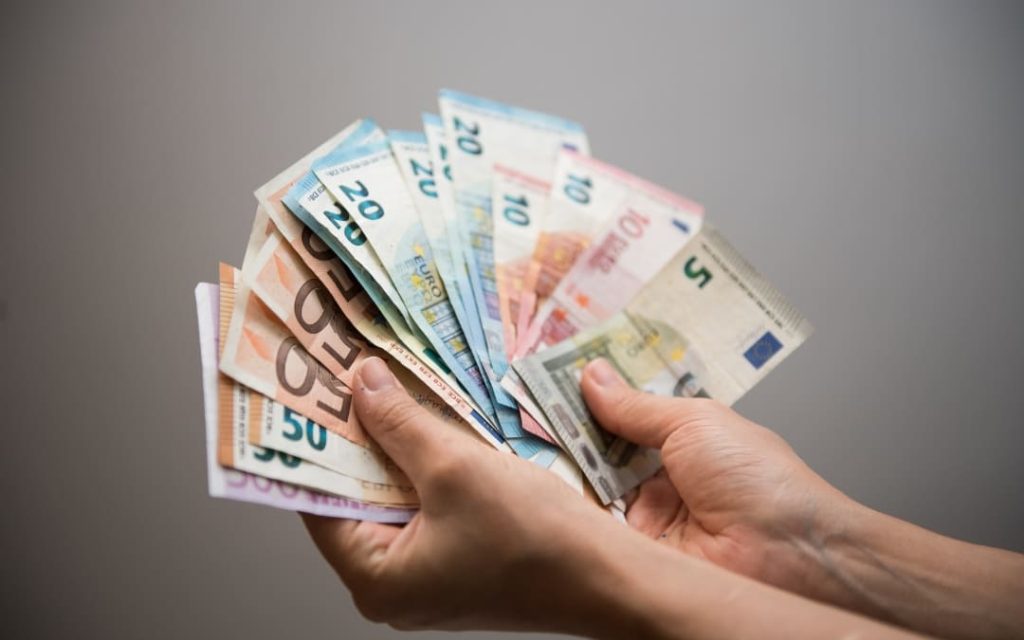 Dłonie trzymające wachlarz banknotów euro o różnych nominałach