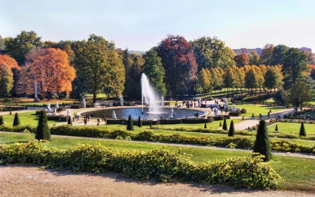 Fontanna w ogrodach Pałacu Sanssouci w Poczdamie otoczona rzeźbami i alejkami parkowymi
