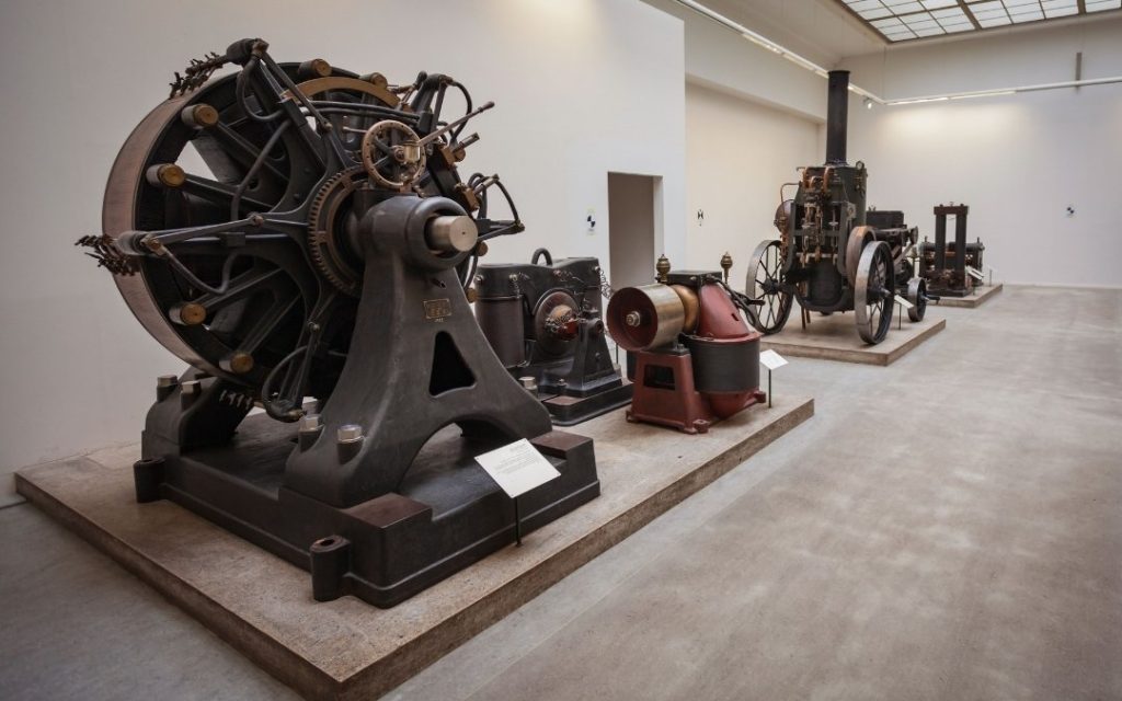Historyczne maszyny przemysłowe w sali Deutsches Technikmuseum w Berlinie, ustawione w rzędzie na ekspozycji technicznej