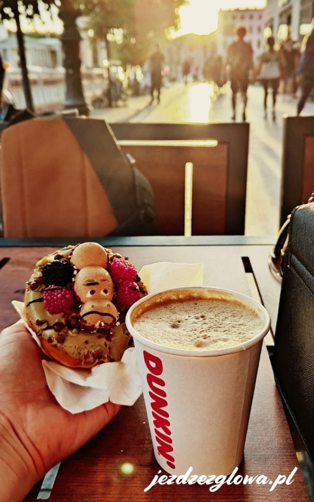 Kawa z Dunkin’ Donuts i donut z owocami przy stoliku