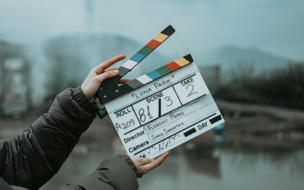 Klaps filmowy trzymany w dłoniach podczas nagrywania filmu