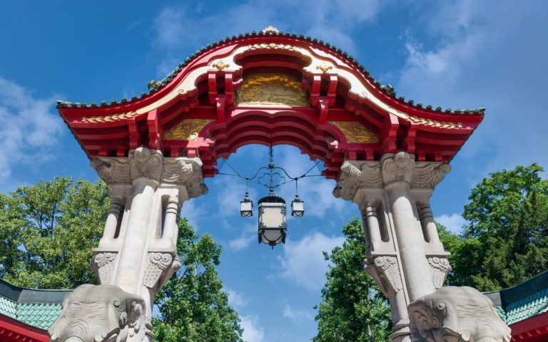 Kolorowa Brama Słoni Elefantentor przy wejściu do Zoo Berlin, z czerwono-złotym dachem, kamiennymi słoniami i ozdobną latarnią
