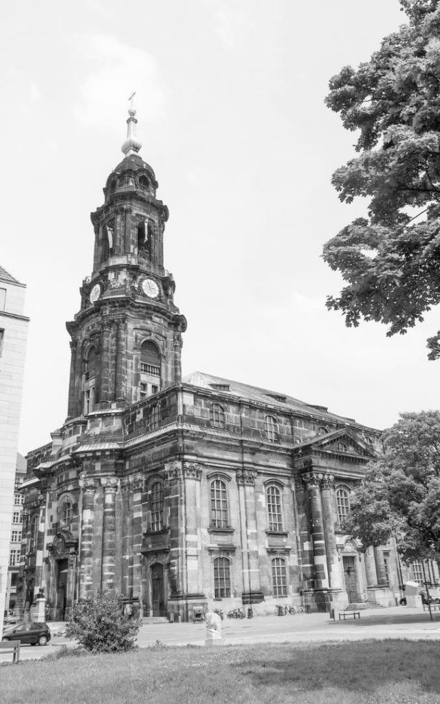 Kościół Świętego Krzyża (Kreuzkirche) w Dreźnie z charakterystyczną wieżą zegarową, sfotografowany z pobliskiego placu w czerni i bieli