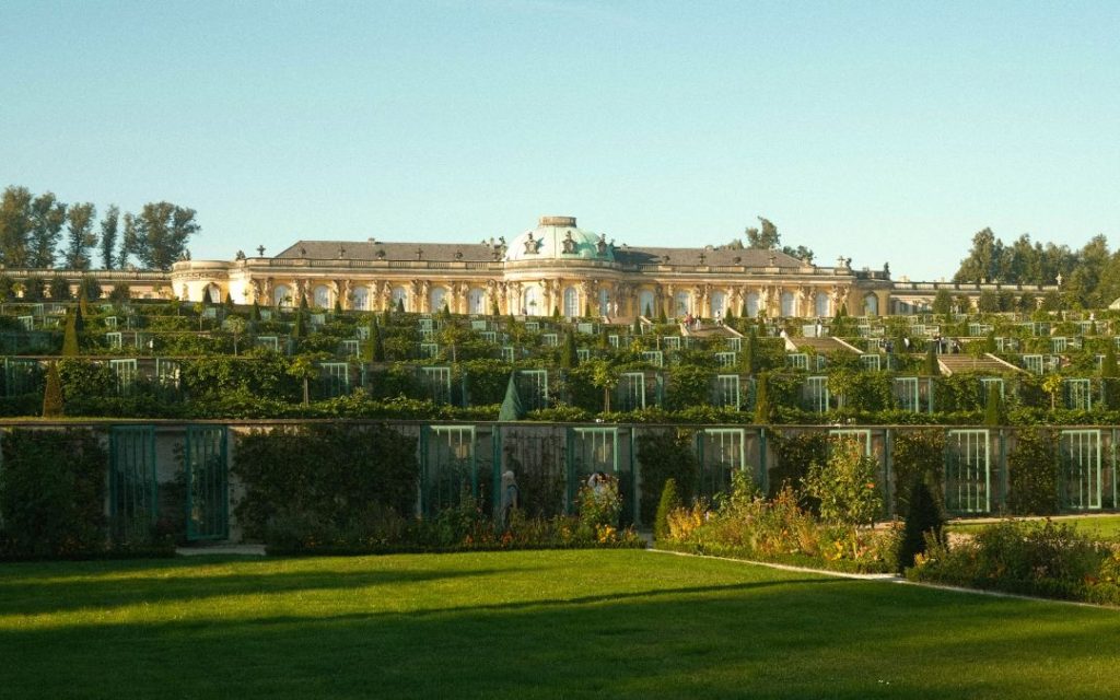 Pałac Sanssouci w Poczdamie z ogrodami o zachodzie słońca
