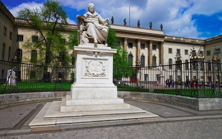 Pomnik Wilhelma von Humboldta przed głównym gmachem Uniwersytetu Humboldtów w Berlinie, za ozdobnym ogrodzeniem przy Unter den Linden