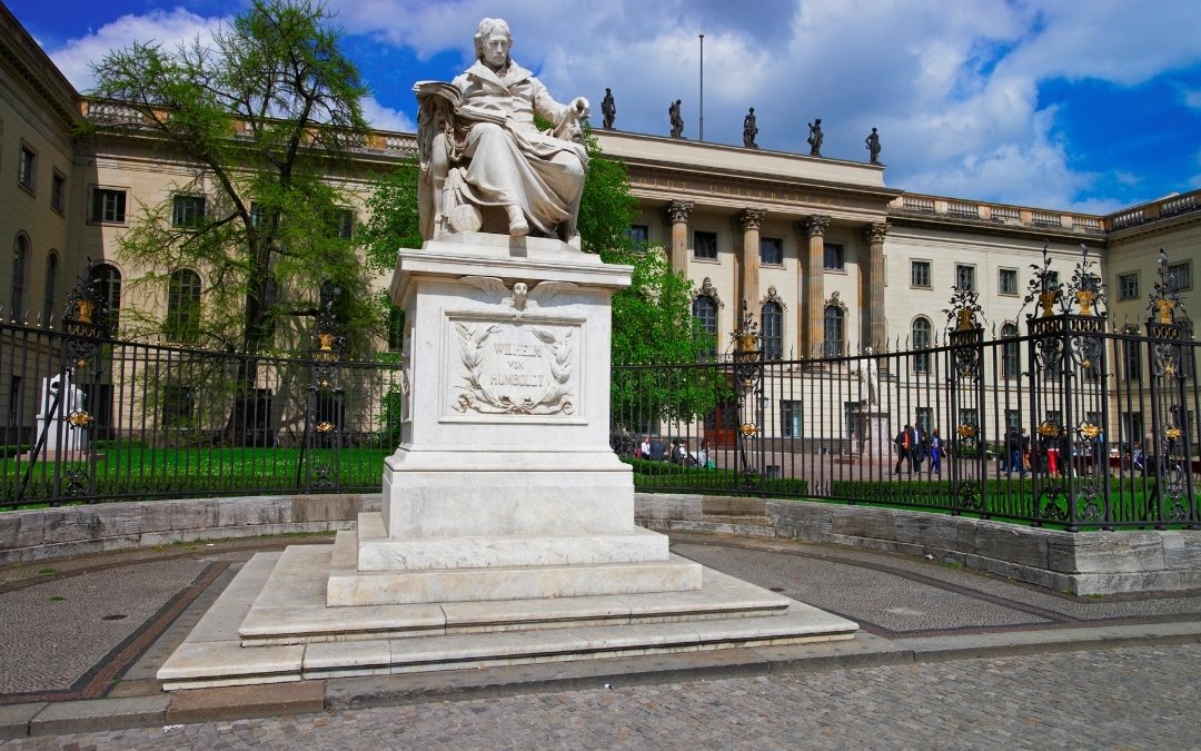 Pomnik Wilhelma von Humboldta przed głównym gmachem Uniwersytetu Humboldtów w Berlinie, za ozdobnym ogrodzeniem przy Unter den Linden