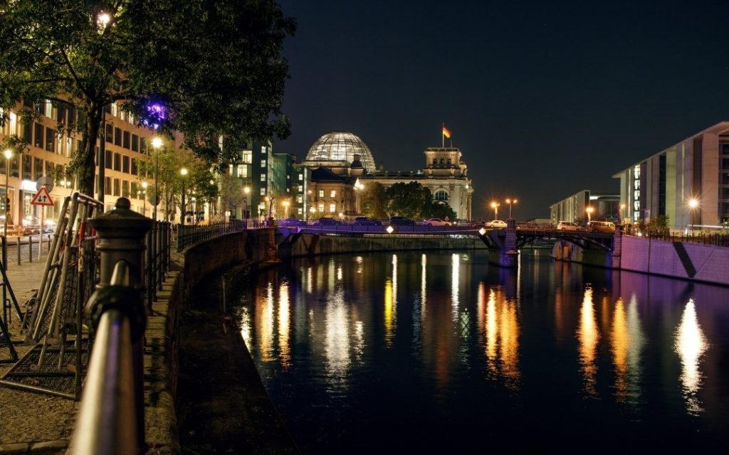 Reichstag nocą nad Sprewą z odbiciami świateł w wodzie