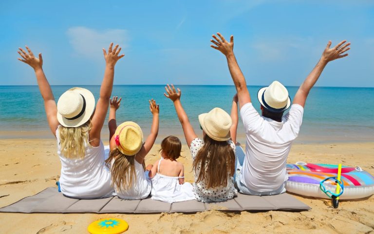 Rodzina z dziećmi odpoczywająca na plaży nad oceanem