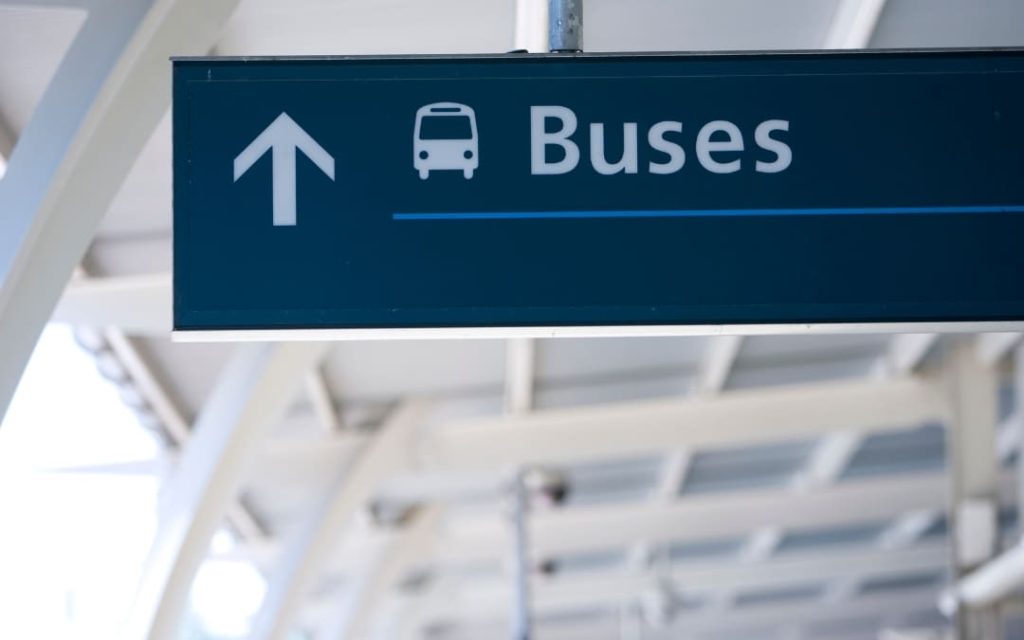 Tablica informacyjna kierująca do autobusów na lotnisku