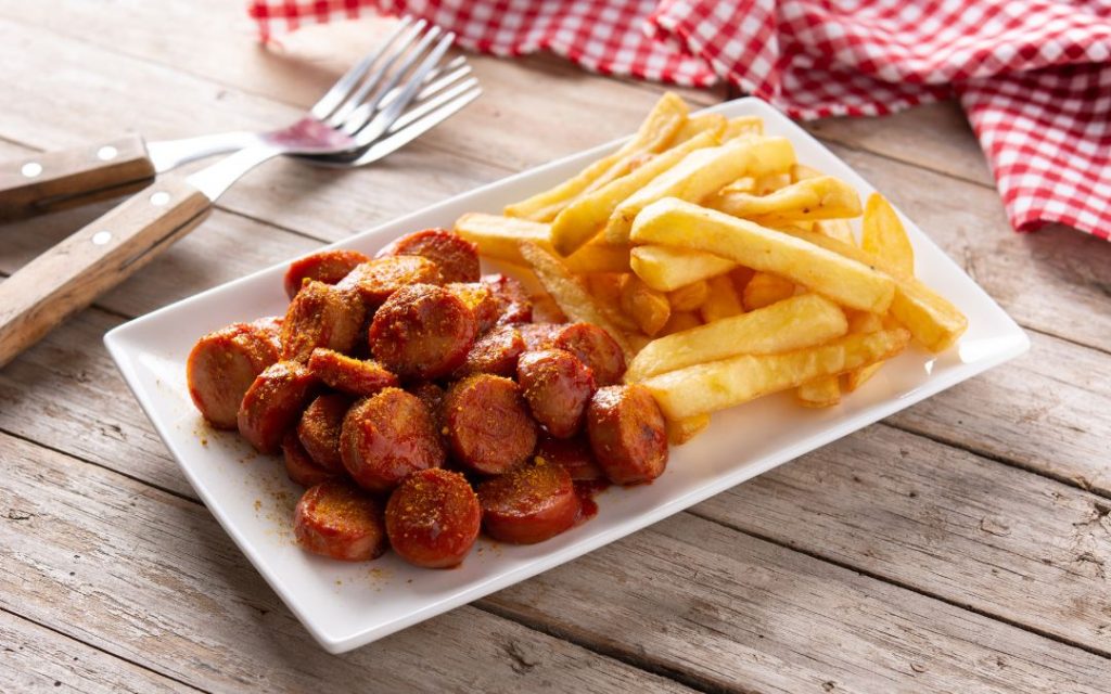 Tradycyjne niemieckie danie - currywurst z frytkami
