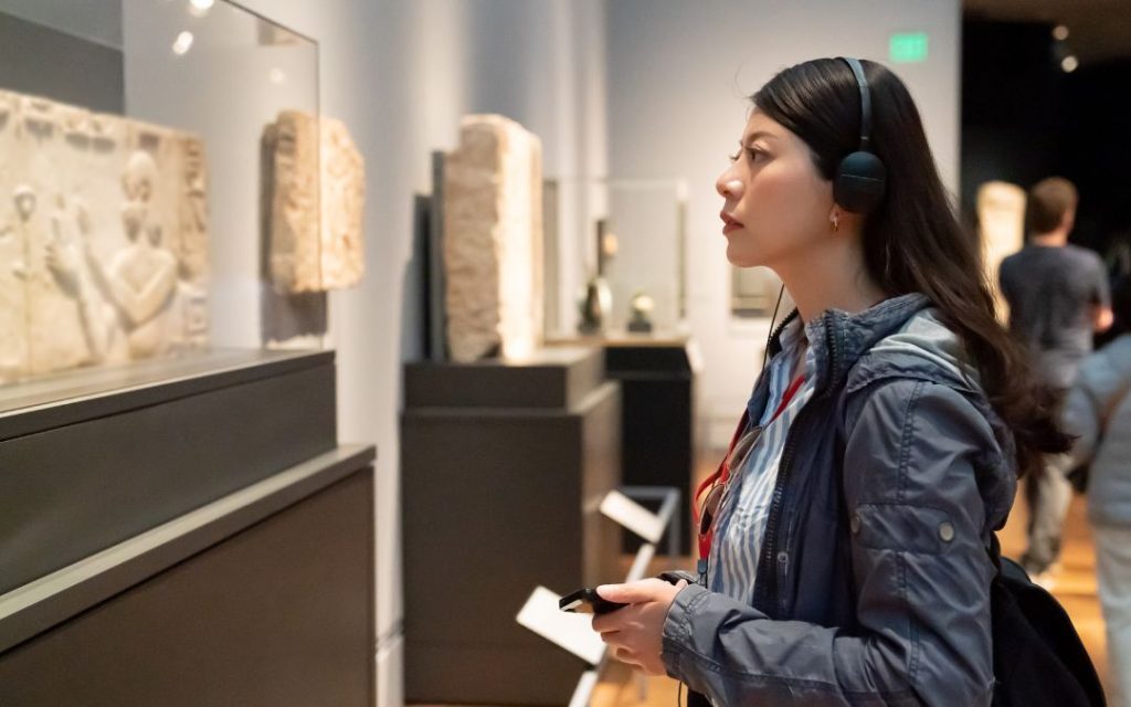 Turystka zwiedzająca muzeum z audioprzewodnikiem