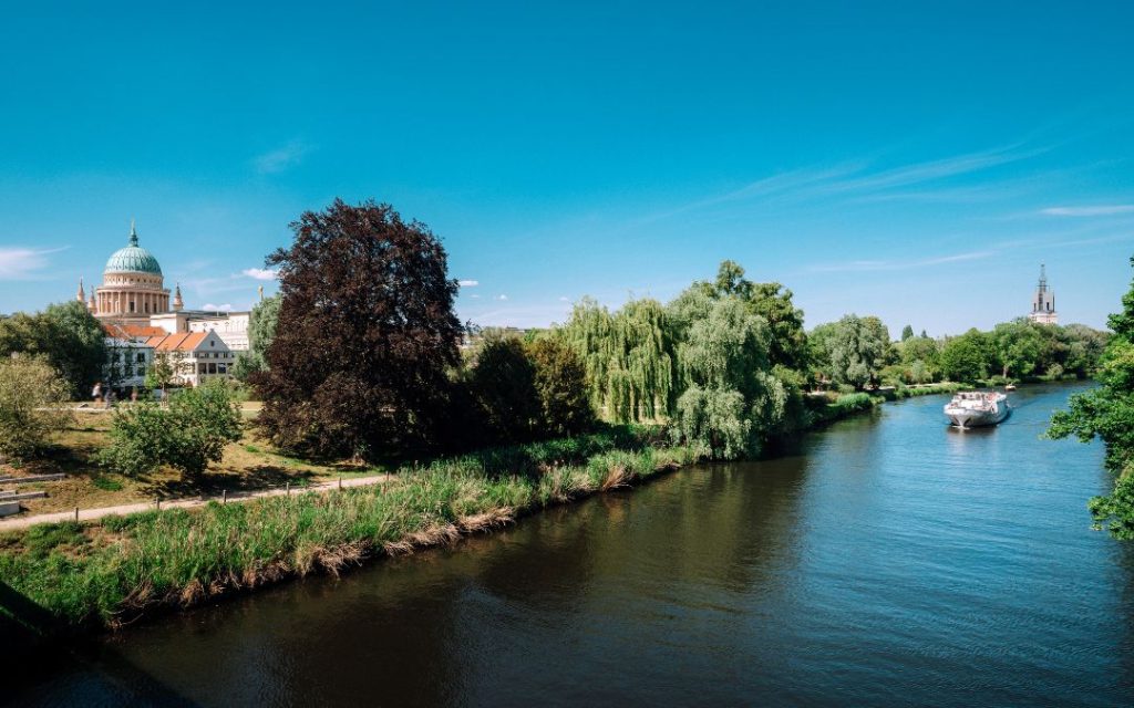 Widok na Poczdam nad Hawelą z łodzią, zielenią i kopułą Kościoła św. Mikołaja
