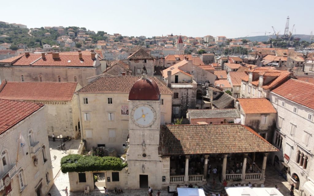 Widok na rynek starego miasta Trogir z wieżą zegarową, loggią miejską i kamienną zabudową Dalmacji