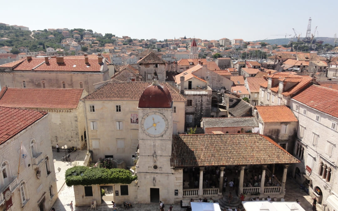 Widok na rynek starego miasta Trogir z wieżą zegarową, loggią miejską i kamienną zabudową Dalmacji