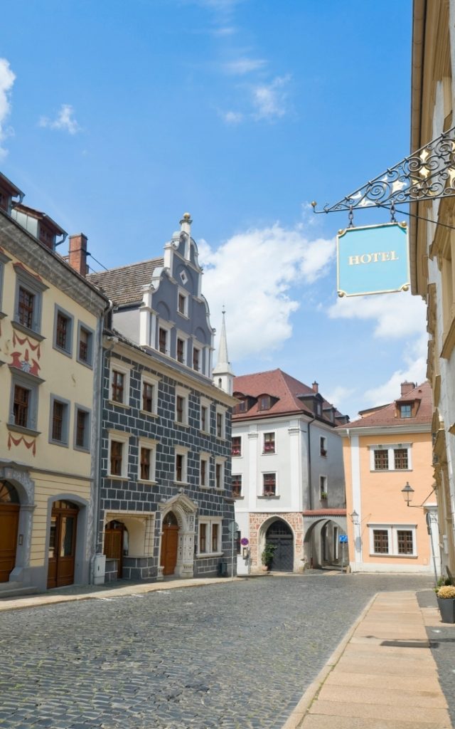 Zabytkowa uliczka w Görlitz z kolorowymi kamienicami i szyldem hotelu