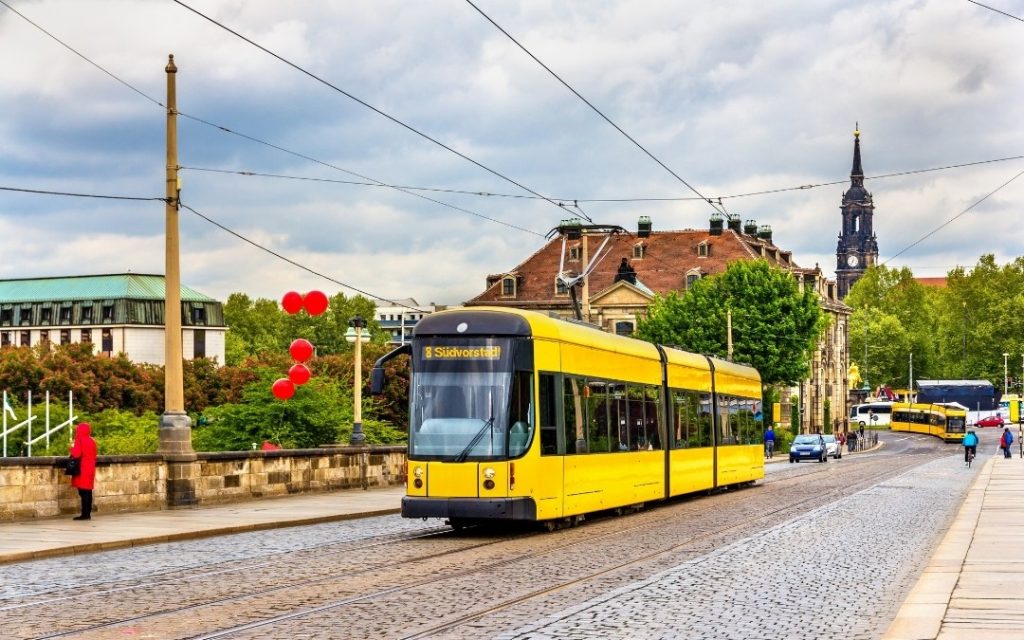Żółty tramwaj w Dreźnie jadący po moście nad Łabą
