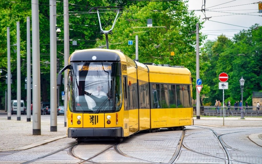 Żółty tramwaj w Dreźnie jadący przez centrum miasta