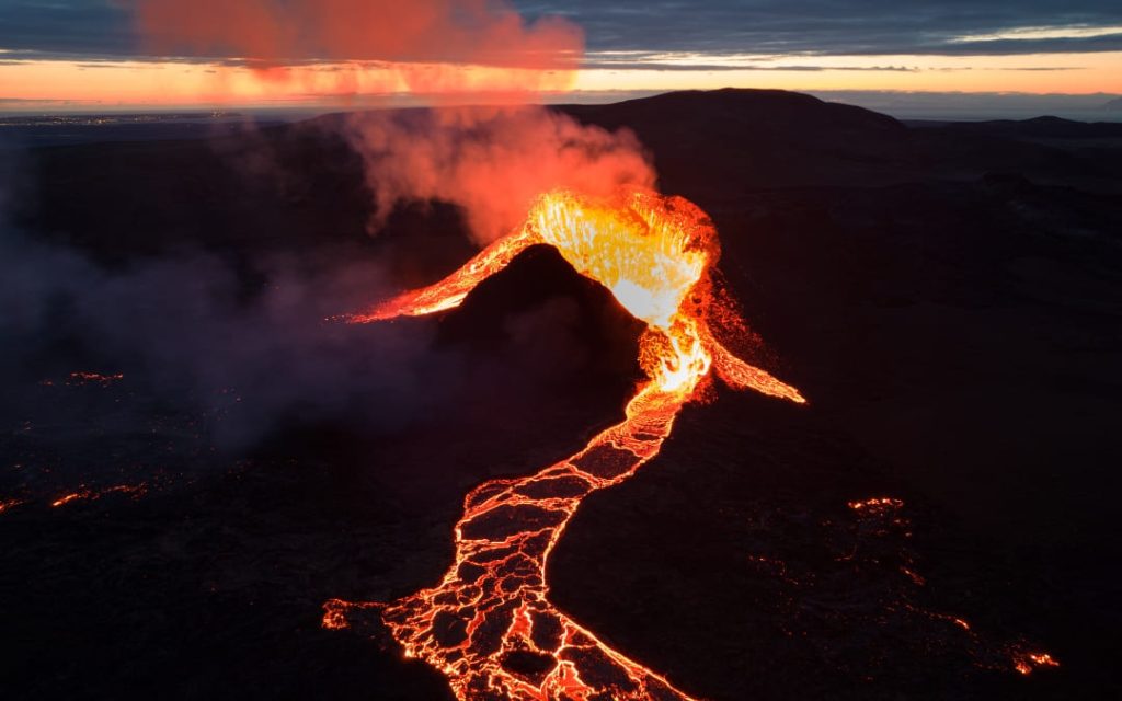 Erupcja wulkanu z płynącą lawą o zmierzchu