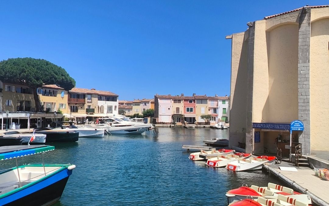 Port Grimaud we Francji – kanał z zacumowanymi łódkami i jachtami otoczony kolorowymi domami