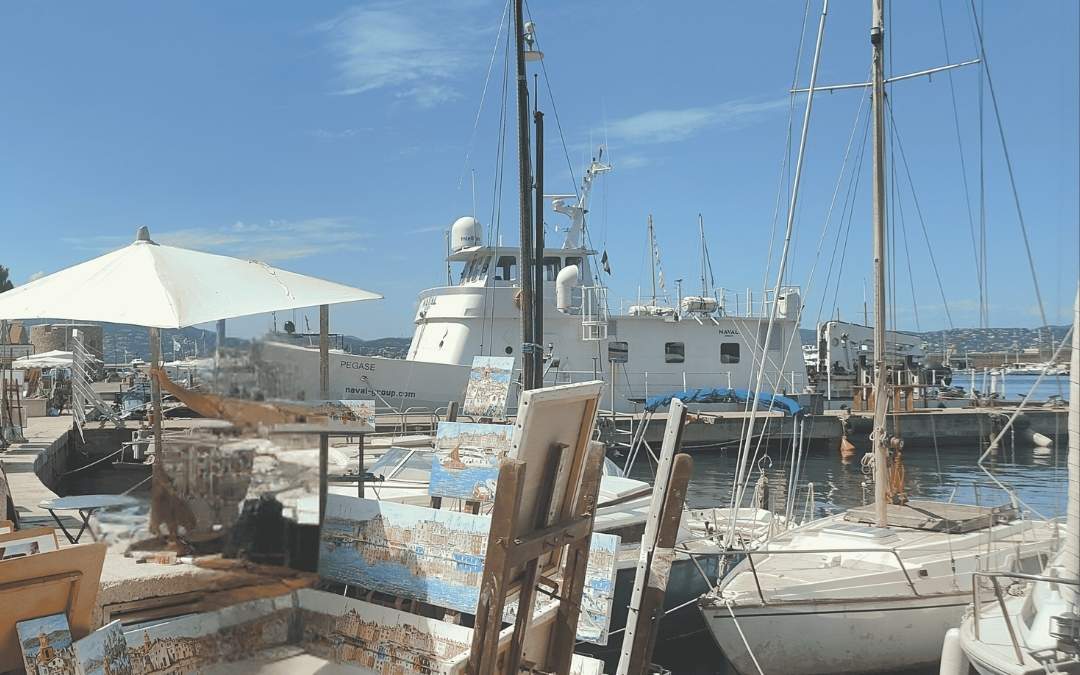 Port w Saint-Tropez – nabrzeżni artyści, sztaluga z obrazami i jachty, klimat Lazurowego Wybrzeża